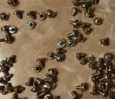 A loose assortment of computer machine screws.\n